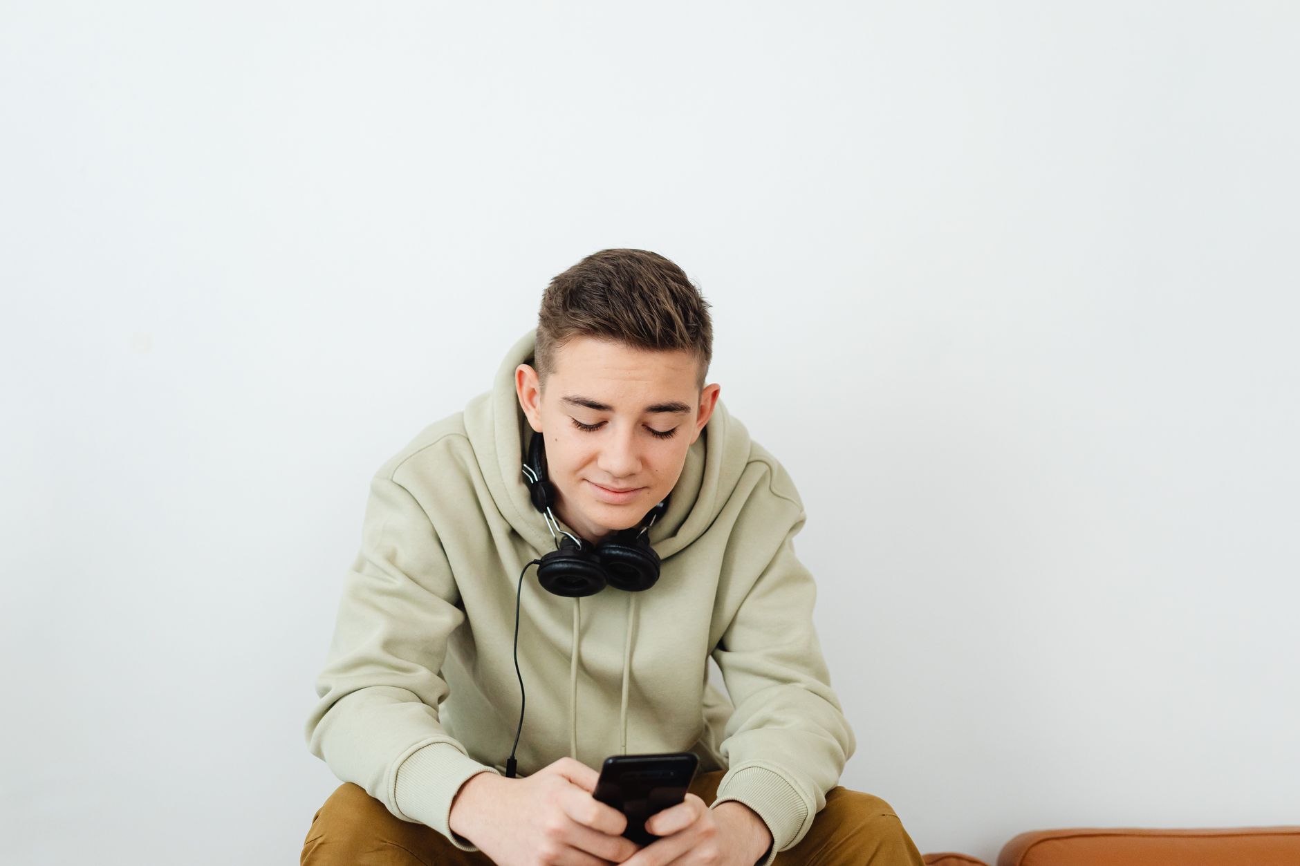 A learner wearing headphones practicing Romanian on a smartphone